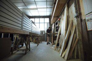 Un homme travaille le bois dans l'atelier Gusmerini