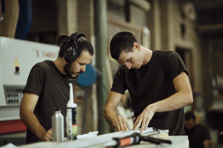 2 hommes collent des éléments dans un atelier