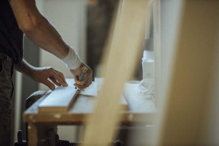 Un homme travaille du bois dans un atelier