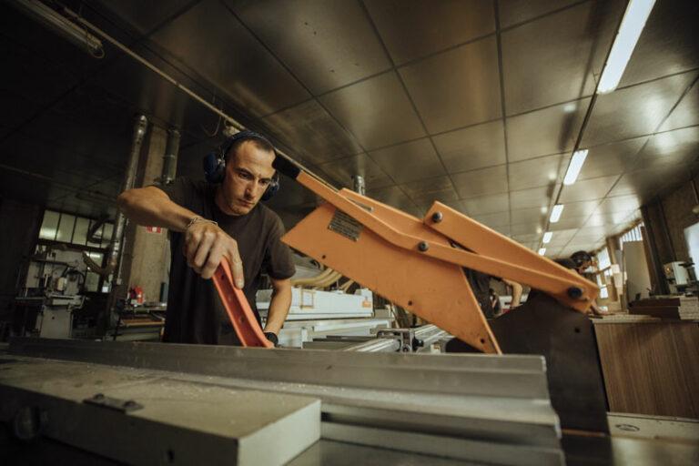 Un homme travaille du bois dans un atelier